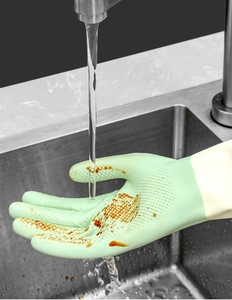 Close-up of green waterproof latex cleaning glove with non-slip texture under running water