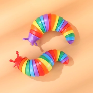 Close-up of two rainbow-colored fidget slugs with flexible joints on a warm background