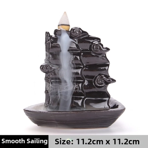 Macro detail of black ceramic backflow incense burner in sailboat design with smoke