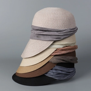Close-up of stackable pleated straw equestrian hats in various neutral colors and textures