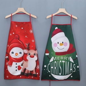 Detail view of red and green Christmas aprons with festive snowman and reindeer prints