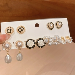 Detailed set of floral and geometric pearl earrings with elegant gold finish and heart motifs