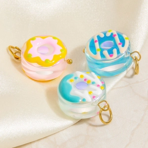 Glazed donut pendants in pink and blue on silk, with gold-toned titanium steel loops