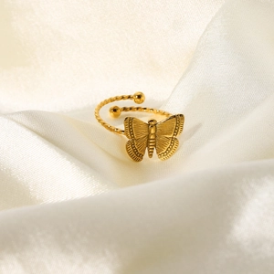 Gros plan sur bague papillon plaquée or 18 carats avec anneau torsadé sur soie