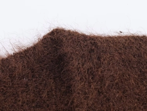 Macro di materiale in fibra di maglia marrone che mostra la trama dettagliata del maglione
