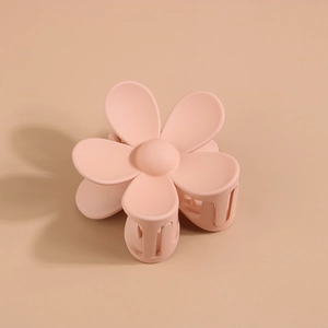 Détail d'une pince à cheveux fleur rose mate avec ressort et dents solides