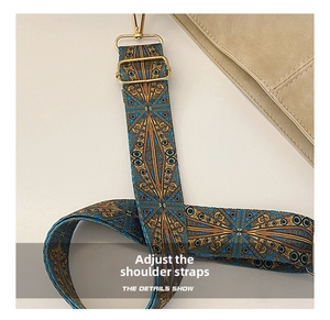 Close-up of ethnic style wide woven strap with colorful patterns and gold hardware