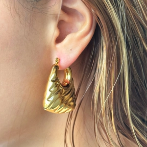 Macro shot of 18k gold plated vintage trapezoid hoop earring with pleated texture