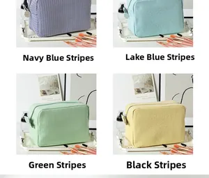 Detail view of multi-color seersucker striped cosmetic bags with metal zipper closure