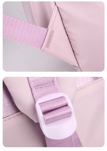Close-up of reinforced stitching and adjustable plastic buckle on purple wool backpack