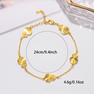 Macro shot of gold clover and butterfly bracelet showing 24cm length and texture