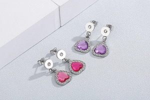 Macro detail of elegant heart-shaped earrings with purple and rose red rhinestones