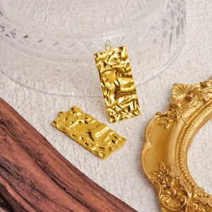 Textured gold rectangle stainless steel pendants on beige background with retro frame