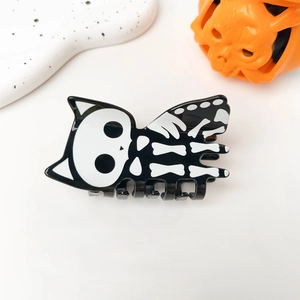 Detail of Halloween hair claw clip featuring a black and white skeleton cat design