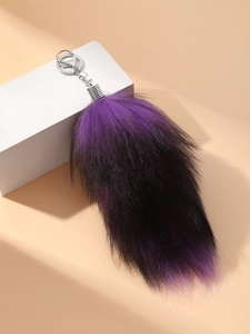 Detail of the oversized gradient purple and black fur tail keychain with silver metal clasp