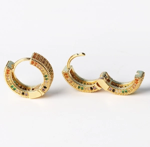 Detail of gold hoop earrings with colorful stones showing the hinged closure mechanism