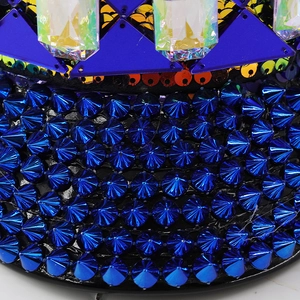 Macro detail of Klein blue studs and iridescent sequins on a punk style captain hat