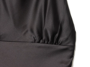 Vue détaillée du tissu en satin noir élégant présentant des plis sophistiqués