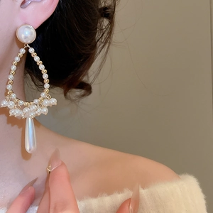 Detailed view of french vintage pearl drop earrings with golden heart tassel silhouette