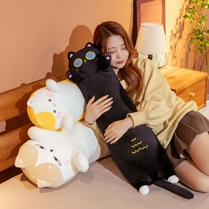 Three long plush cat pillows in black, yellow, and brown displayed on a warm home sofa