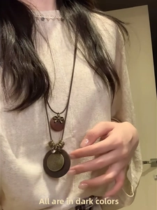 Close-up of vintage magnetic leather eyeglass clip necklace with bronze pendant details