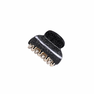 Detail view of small black glitter hair claw clip with metallic silver shimmer finish