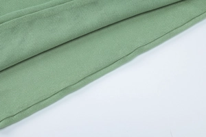 Detailed macro shot of light green knitted mesh fabric with natural pleated texture