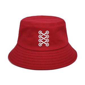 Close-up of red cotton bucket hat featuring white crisscross embroidery and stitched brim