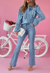 Ensemble chemise en denim bleu clair et jean évasé sur fond rose pour femme