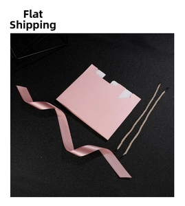 Flat lay of pink wedding gift bag components with silk ribbon and woven handles