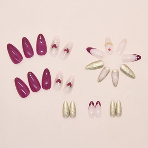 Detail of press-on nails with purple hearts, pearls, and golden embossed wave patterns