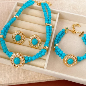 Parure de bijoux vintage avec perles turquoise et métal doré dans un écrin en velours