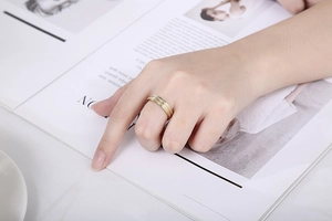 Detail shot of a two-tone frosted stainless steel ring worn on a finger with a modern style