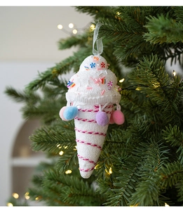 Close-up of ice cream Christmas tree ornament with colorful pom-poms and warm lighting