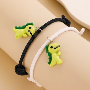 Detail der geflochtenen Magnetarmbänder mit süßen grünen Dinosauriern für Paare