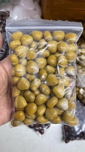 Close-up of polished 15mm yellow heart-shaped natural crystal stones in a clear bag