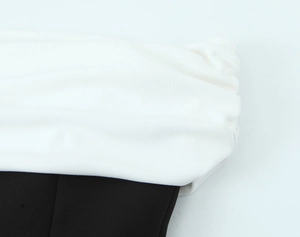 Gros plan sur les coutures contrastées noir et blanc et le détail du tissu en mousseline