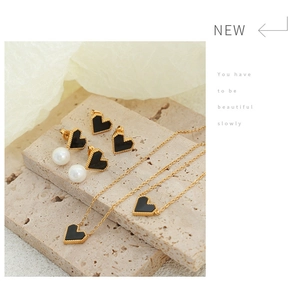 Detail of 18K gold plated necklace and earrings with black heart shell and pearl accents