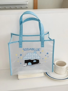 Detail of transparent PVC beach bag with blue dog print and faux leather handle