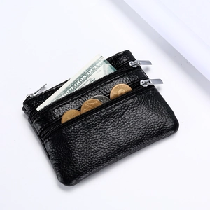 Close-up of black pebble leather coin purse with three zippers and silver metal hardware