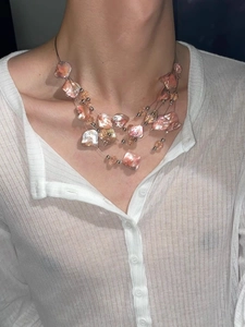 Détail du pendentif en coquillage rose et collier bohème multicouche sur le décolleté