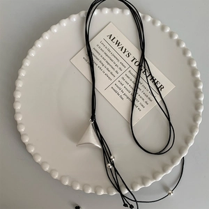 Macro detail of geometric triangular pendant on minimalist black leather necklace