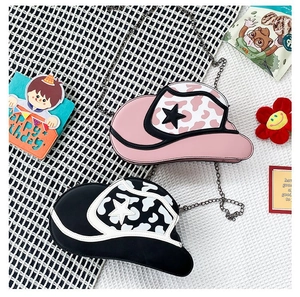 Detailed top view of pink and black cowboy hat shaped chain bags with cow print stars
