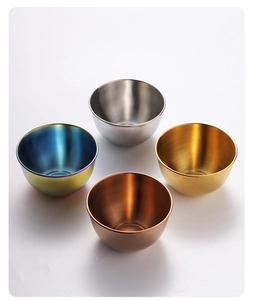 Overhead view of four stainless steel sauce bowls in silver, gold, rose gold, and iridescent
