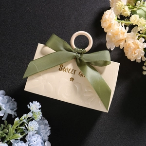 Detail of champagne wedding gift box with wooden ring handle and green ribbon bow