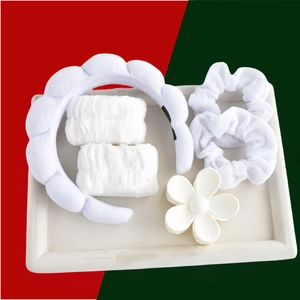 Close-up of a 6-piece white spa set with plush headband, wristbands, and floral hair claw