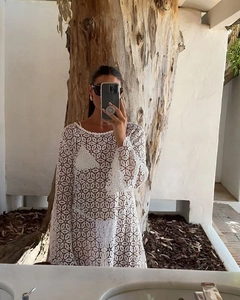 Detail shot of white crochet lace beach cover-up with intricate floral hollow out patterns