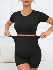 Seamless high-waist maternity yoga set with supportive black knit top and peach-lift shorts