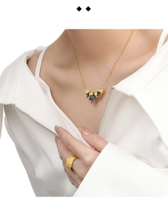 Detail shot of golden leaf necklace with black texture and matching textured metal ring
