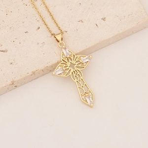 Detailed macro view of 18K gold plated cross pendant with cubic zirconia on stone base